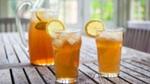 Picture of 2 glasses of iced tea with lemon along with a pitcher of iced tea