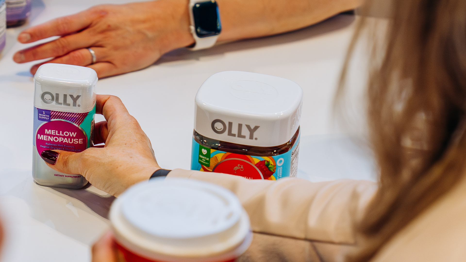 Person reaching for OLLY products
