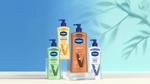 Four Vaseline Intensive Care lotions, including ‘Soothing Hydration’, ‘Nourishing Moisture’, ‘Cocoa Radiant’ and ‘Advanced Repair’. Each bottle is equipped with a recyclable pump dispenser. The products are arranged in front of a blue background, with a leaf motif.