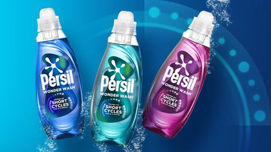 Three Persil Wonder Wash bottles in blue, teal and pink variants on a blue background with water splash effects.