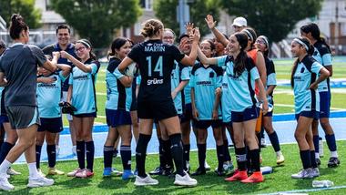 Team of smiling young girl soccer players high fiving members of the Unilever sponsored Gotham FC women’s soccer team.